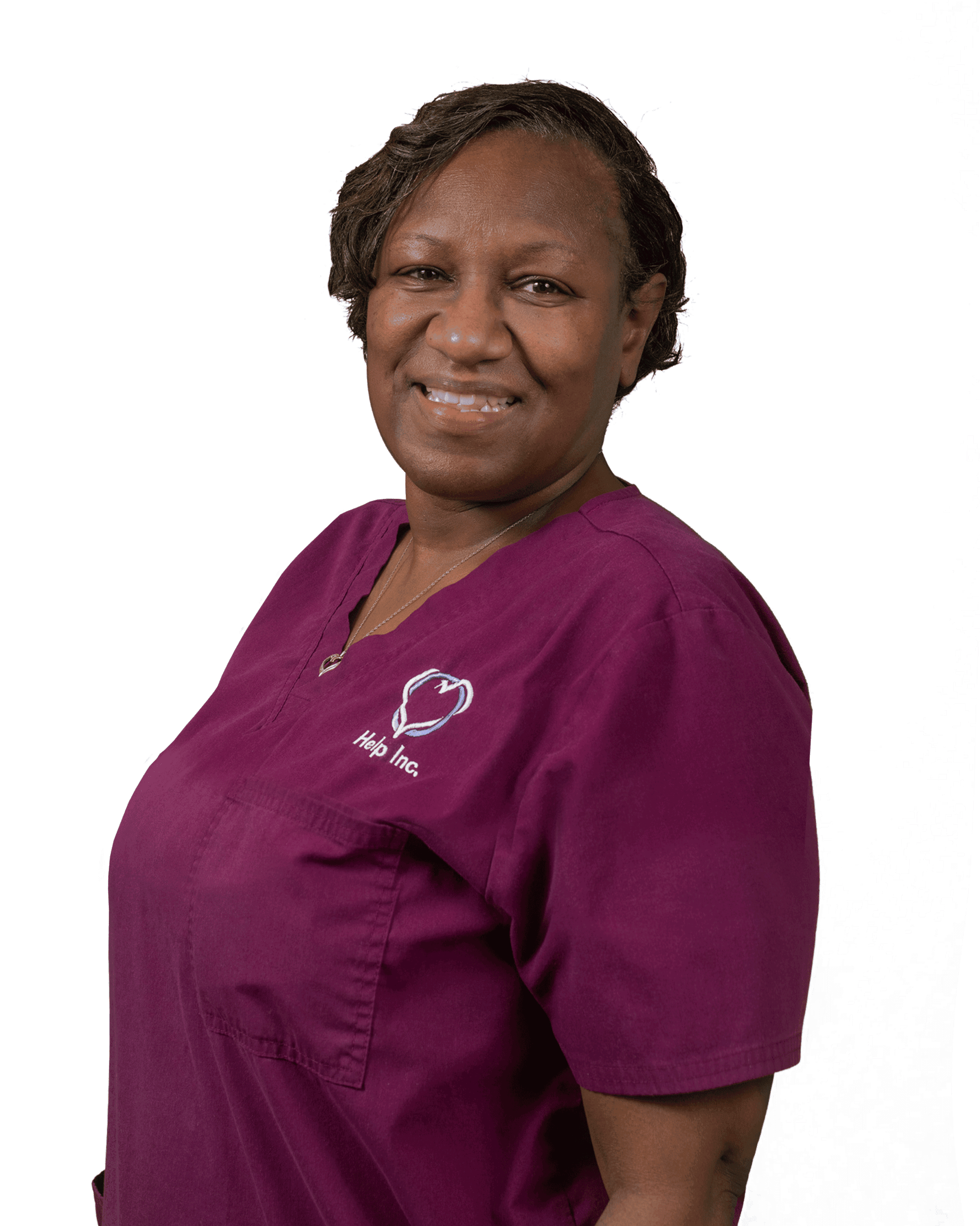 A woman wearing a maroon scrub top with a heart and "Help Inc." logo stands smiling against a white background.