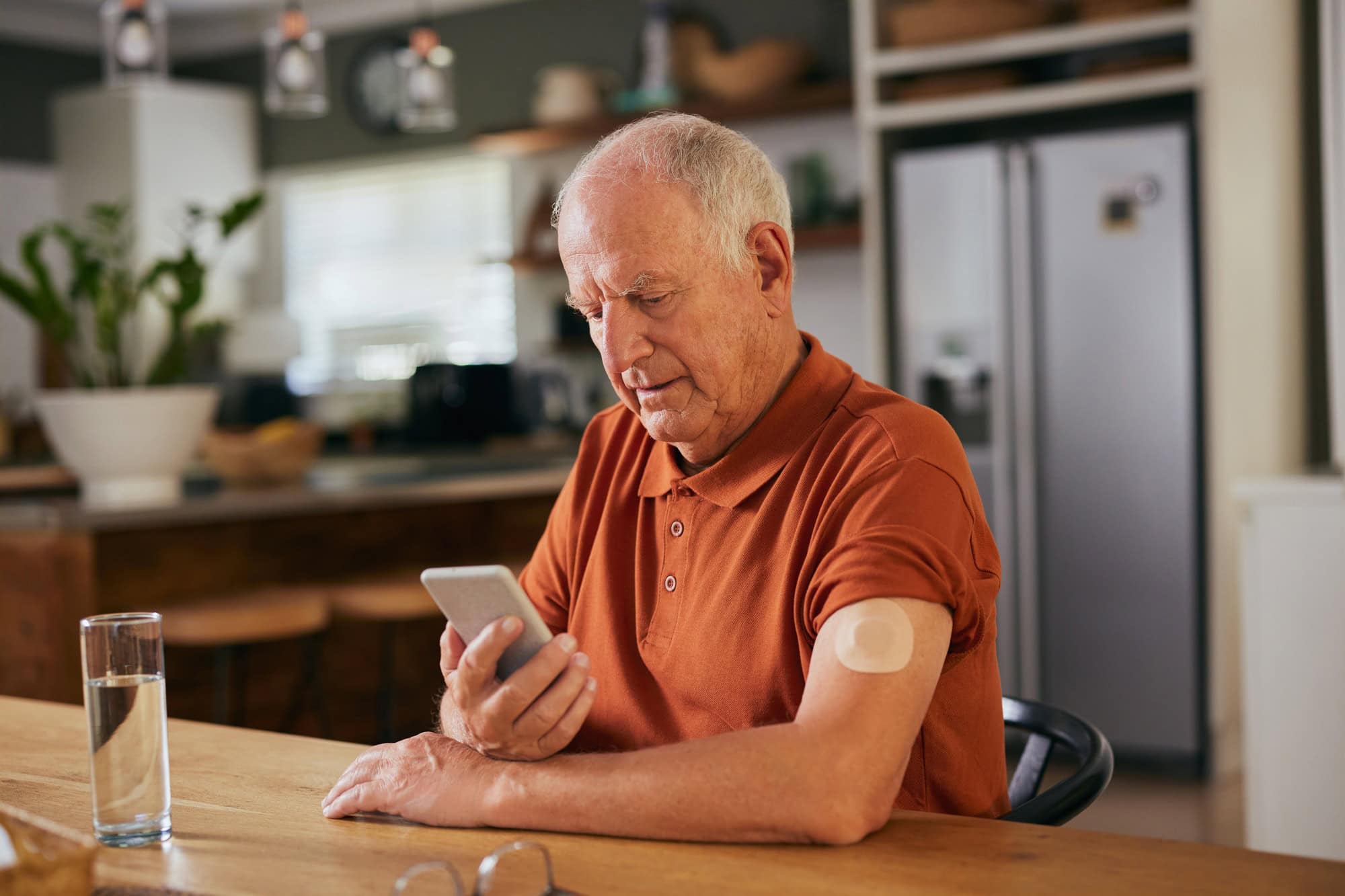 Diabetic senior man checking glucose on digital app