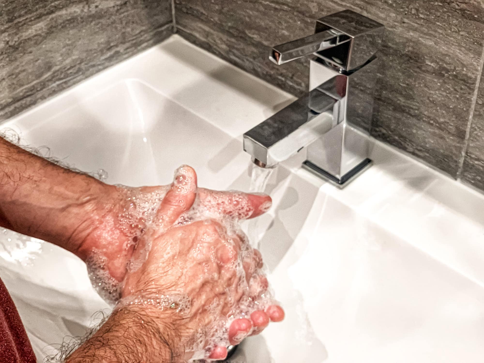 Personal hygiene: man is washing hands with soap properly at home